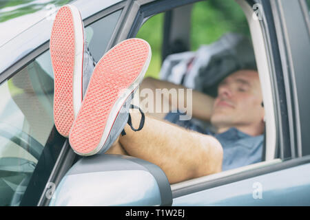 Mann schlafen im Auto vor dem nächsten Teil der jurney Stockfoto