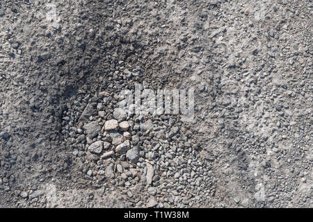 Schlagloch im hardcore Kies Land verfolgen. Metapher für schlecht gewartete Straßen, holperig, rough Road, schlechte Straßen, Loch in der Straße. Stockfoto