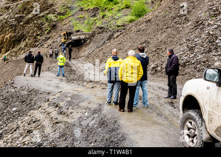 Omalo, Georgien - 11. Juni 2016: Arbeitnehmer mit Traktor der Erdrutsch am Berg Straße entfernen, Tuscheti Stockfoto