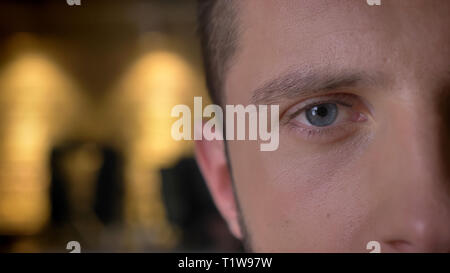 Closeup halben Gesicht vorne Schießen von Erwachsenen kaukasischen männliche Auge von der Kamera drinnen auf der Suche mit Innen auf dem Hintergrund Stockfoto