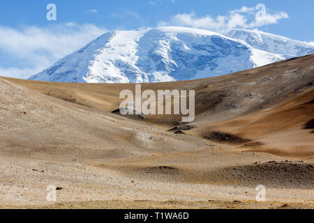 KARAKUL SEE, XINJIANG/CHINA - Oktober 2, 2017: Muztagh Ata Berg hinter sanften Hügel, Hänge (See Karakul, an der Autobahn von Karakorum dem Erdboden). Stockfoto