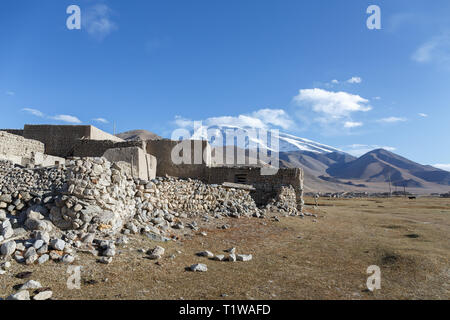 Traditionelles Haus vor Mount Muztagata II. In der Nähe von Lake Karakul (Karakorum Highway, Provinz Xinjiang, China) erfasst Stockfoto