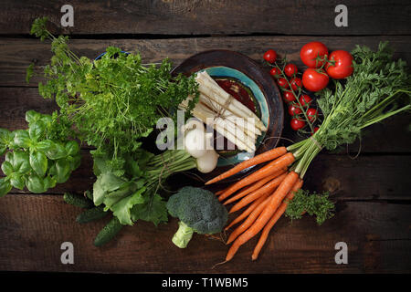 Horizontale Komposition von frischen, rohen Gemüse auf einem Holz- Hintergrund. Ansicht von oben Stockfoto