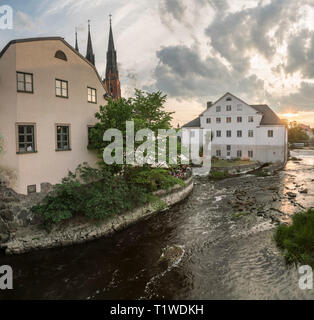 Alte Mühle am Kvarnfallet im fyris Fluss mit der Kathedrale (Domkyrkan) im Hintergrund bei Sonnenuntergang. Uppsala, Schweden, Skandinavien Stockfoto