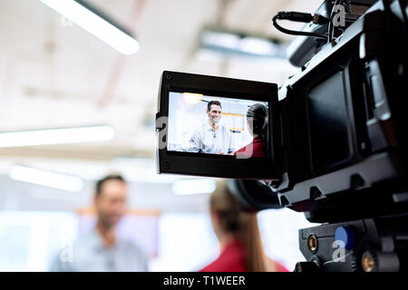 Happy Geschäftsmann während Corporate Interview mit der Journalistin. Manager Beantwortung der Frage im Amt. Junge Frau bei der Arbeit als Reporter mit busine Stockfoto