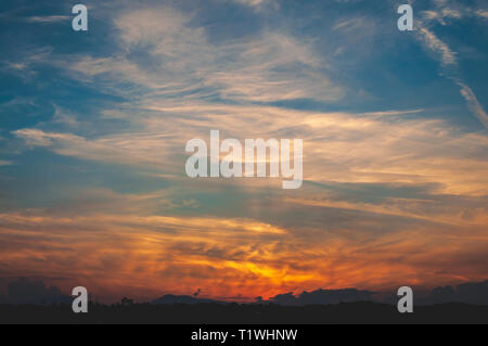 Atemberaubenden Sonnenuntergang am Meer und in den Bergen, im Hafen, mit lebendigen und warmen orange Farben und schönen bewölkten Himmel. Foto in Italien Stockfoto