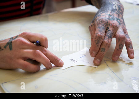 April 16, 2017. Ukraine, Kiew. Die Hände eines Mannes mit einem Filzstift markieren Sie die Form einer Schablone auf das Glas für die Glasmalerei Stockfoto