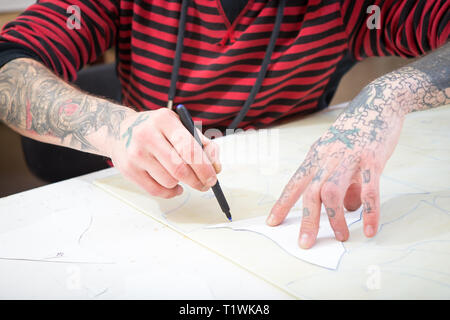 April 16, 2017. Ukraine, Kiew. Die Hände eines Mannes mit einem Filzstift markieren Sie die Form einer Schablone auf das Glas für die Glasmalerei Stockfoto