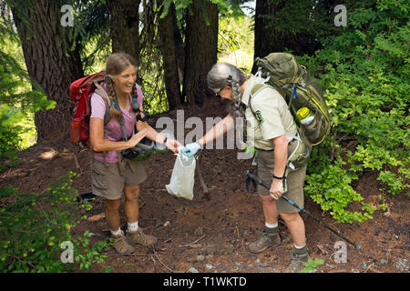 WASHINGTON - Forest Service Freiwillige Jane Ellen Seymour, mit einem semi-begeisterte Helfer, Müll und Fäkalien von Wanderern. Stockfoto