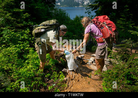 WASHINGTON - Forest Service Freiwillige Jane Ellen Seymour, mit einem semi-begeisterte Helfer, Müll und Fäkalien von Wanderern. Stockfoto