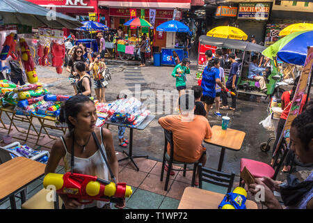 Junges Mädchen mit Wasserpistole feiert die thailändischen Neujahr Songkran in der Khaosan Road, Bangkok, Thailand Stockfoto