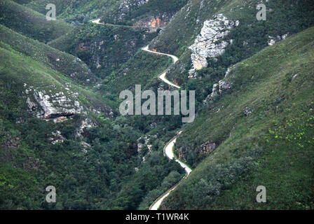 Von einem Pass Highway in der Nähe von George, Südafrika sehen Sie den alten Schmutz der Straße schlängelt sich durch die Berge. Stockfoto