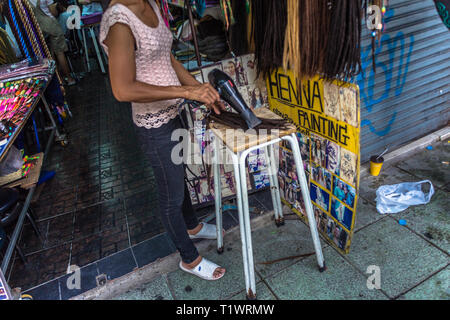 Ein Mädchen trocknen Perücken in Bangkok, Thailand Stockfoto