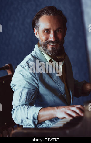 Stattliche Musiker komponiert Musik am Klavier sitzen Stockfoto