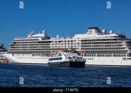 Lokale Fahrgast Katamaran Ekspressen vorbei Kreuzfahrtschiff Viking Sky (skolten Terminal). Der Katamaran ist Ankunft in den Hafen von Baratti Stockfoto