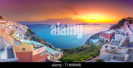 Blick am Abend von Fira, Caldera, Vulkan von Santorini, Griechenland mit Kreuzfahrtschiffen bei Sonnenuntergang. Dramatischer Wolkenhimmel. Stockfoto