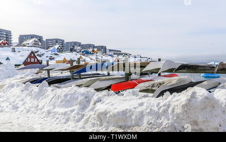 Inuit Kajaks gespeichert für einen Winter im Schnee mit modernen Gebäuden und kleine Hütten im Hintergrund, Nuuk Hafen der Altstadt, Grönland 8. Stockfoto