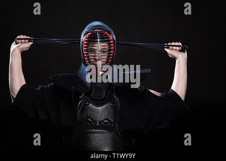 Kendo Kämpfer in Rüstung, Helm auf Schwarz Stockfoto