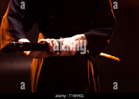 Teilansicht des Kendo Kämpfer Holding bambo Schwert auf Schwarz Stockfoto