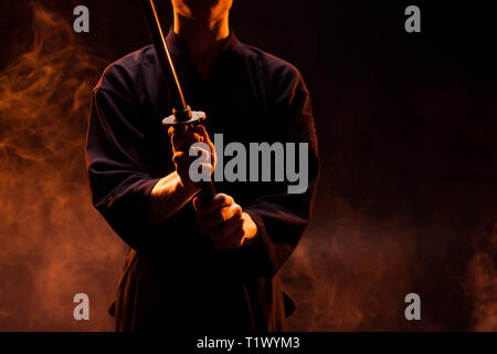 Der junge Mann im Kimono Holding kendo Schwert in Rauch 7/8 Stockfoto