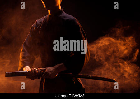 Der junge Mann im Kimono Holding kendo Schwert in Rauch 7/8 Stockfoto