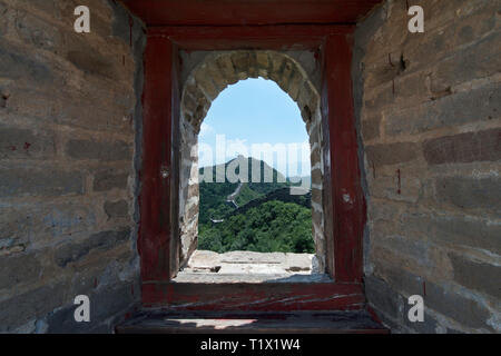 Blick durch ein Backstein Fenster einer Festung Wachturm von Mutianyu, einem Abschnitt der Großen Mauer von China im Sommer. Bezirk Huairou, Peking Stockfoto