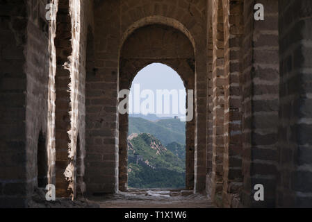 Blick durch ein Backstein Fenster einer Festung Wachturm von Mutianyu, einem Abschnitt der Großen Mauer von China im Sommer. Bezirk Huairou, Peking Stockfoto