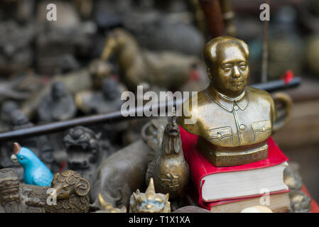 Pingyao, China - 08 13 2016: Oldtimer und alte chinesische Bronze großer Führer Mao Zedong Büste Kopf kleine Statue in einer Straße Markt in Pingyao, China Stockfoto