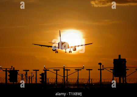 Airliner Landung am Flughafen Heathrow bei Sonnenuntergang Stockfoto
