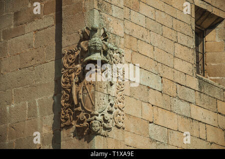 Nahaufnahme des Familienwappens Skulptur an der Ecke einer Stein Backsteingebäude in Caceres. Eine charmante Stadt mit einem vollständig erhaltenen Altstadt in Spanien. Stockfoto