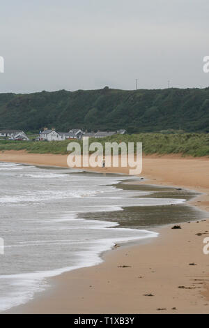 Person zu Fuß an einem Sandstrand in County Donegal, Irland. Culdaff Strand auf der Halbinsel Inishowen. Stockfoto