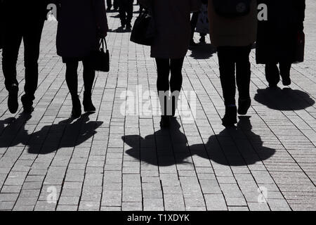 Silhouetten und Schatten der Menschen auf der Straße. Menge hinunter auf Bürgersteig, Konzept der Gesellschaft, Bevölkerung, Fußgänger, städtischen dramatische Leben Stockfoto