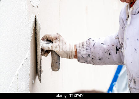 Bauarbeiter Verputzarbeiten und Glättung Betonwand mit Zement. Stockfoto