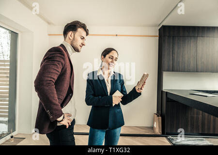 Interior Designer trägt blaue Jacke bietet einige Farben für Küche Stockfoto