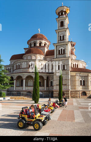 Kinder spielen auf miniatur Autos vor der Orthodoxen Kathedrale und Korca Korca, Südosteuropa Albanien. Stockfoto