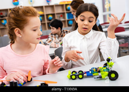 Die Schülerinnen und Schüler Schreibtisch mit pädagogische Spielwaren während der Lektion im Klassenzimmer sitzen Stockfoto