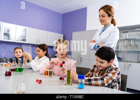 Schüler holding Molekül Strukturen während der Sitzung in Klassenzimmer während Chemie Lektion Stockfoto