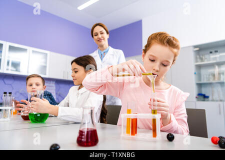 Schülerinnen und Schüler mit Flaschen zu tun chemische Experiment während Chemie Lektion Stockfoto
