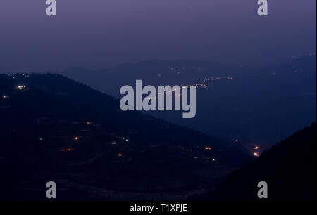 Ferne Lichter auf einem dunklen Berg Landschaft bei Nacht Stockfoto