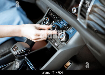 Frau drehenden Rad der Klimaanlage im Auto, Nahaufnahme Stockfoto