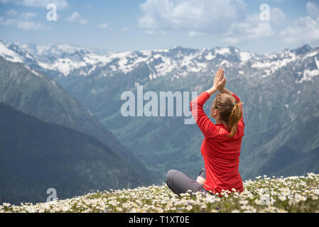 Junge Frau mit Yoga auf einem Berg Stockfoto