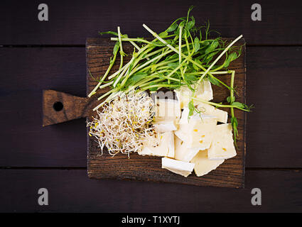 Weiche brie Käse und microgreens auf einem Holzbrett Stockfoto