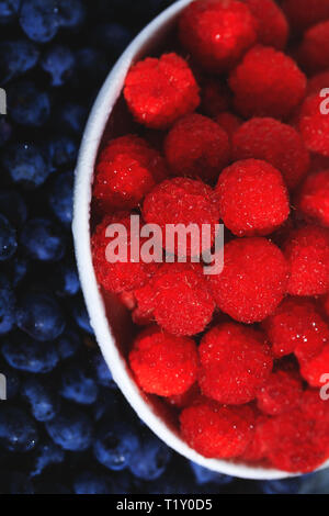 Schöne Himbeeren Obst Hintergrund. Süße Himbeere in Weiß Schüssel Reif. Nahaufnahme, Ansicht von oben, hohe Auflösung. Sammlung von organischen und Nat Stockfoto