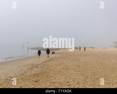 Poole, Dorset, Großbritannien. 29. März, 2019. Misty Morning für Menschen und Hunde gehen und laufen am Strand. Credit: Suzanne McGowan/Alamy leben Nachrichten Stockfoto