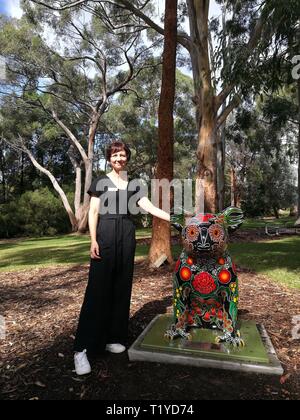 (190329) - Canberra, 29. März 2019 (Xinhua) - die Gärten' Besucher Erfahrung Koordinator Megan Donaldson steht neben einem Koala Statue an der Australian National Botanic Gardens in Canberra, Australien, 28. März 2019. Eine 14 Meter hohe koala Statuen von verschiedenen Künstlern gestaltet werden über die Australian National Botanic Gardens verstreut, auf dem Boden sitzend für Besucher Geschichten hinter ihnen auf März 1-31 zu entdecken. Die Gärten' Besucher Erfahrung Koordinator Megan Donaldson sagte, dass die Pop-up-Statuen zielten darauf ab, das Bewusstsein für australische Pflanzen und Fauna zu erhöhen. Stockfoto