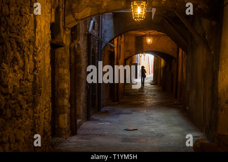 Frau zu Fuß durch die Rue Obscure" (Versteckte Straße), Villefranche, südlich von Frankreich Stockfoto