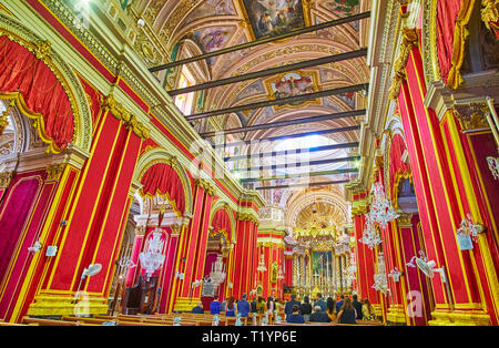 SIGGIEWI, MALTA - 16. JUNI 2018: reich verzierten Inneneinrichtung von San Nikola (St. Nikolaus) Kirche mit verzierten Kuppel und Wände, mit hellen roten Tex abgedeckt Stockfoto
