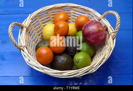 Exotische Früchte im Korb: Zitronen, Granadilla (Fruit of the Loom), Mandarinen, Avocados. Stockfoto