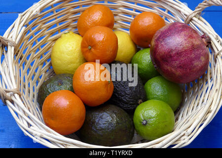 Exotische Früchte im Korb: Zitronen, Granadilla (Fruit of the Loom), Mandarinen, Avocados. Stockfoto