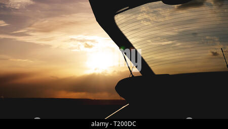 Im Kofferraum bei Sonnenuntergang, Foto gegen die Sonne - Travel Concept Stockfoto